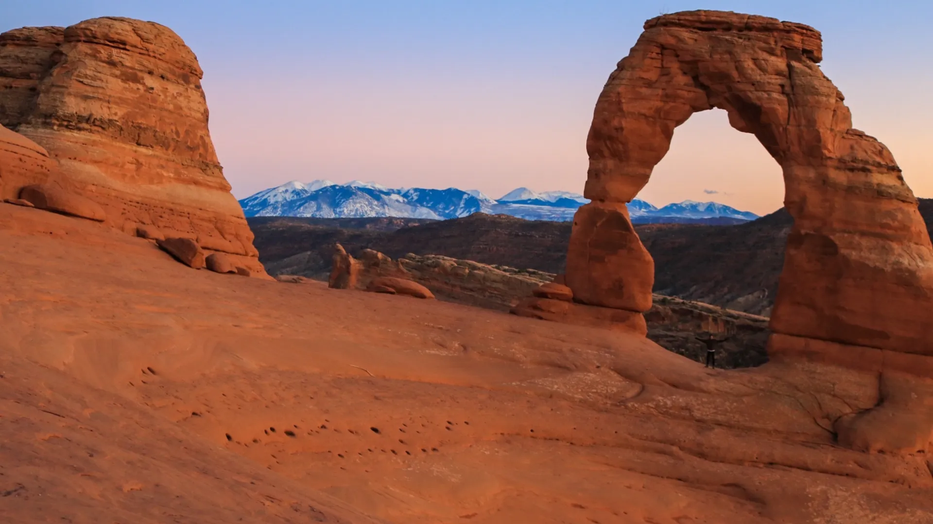 Delicate Arch glowing above the red rock landscape in Arches National Park