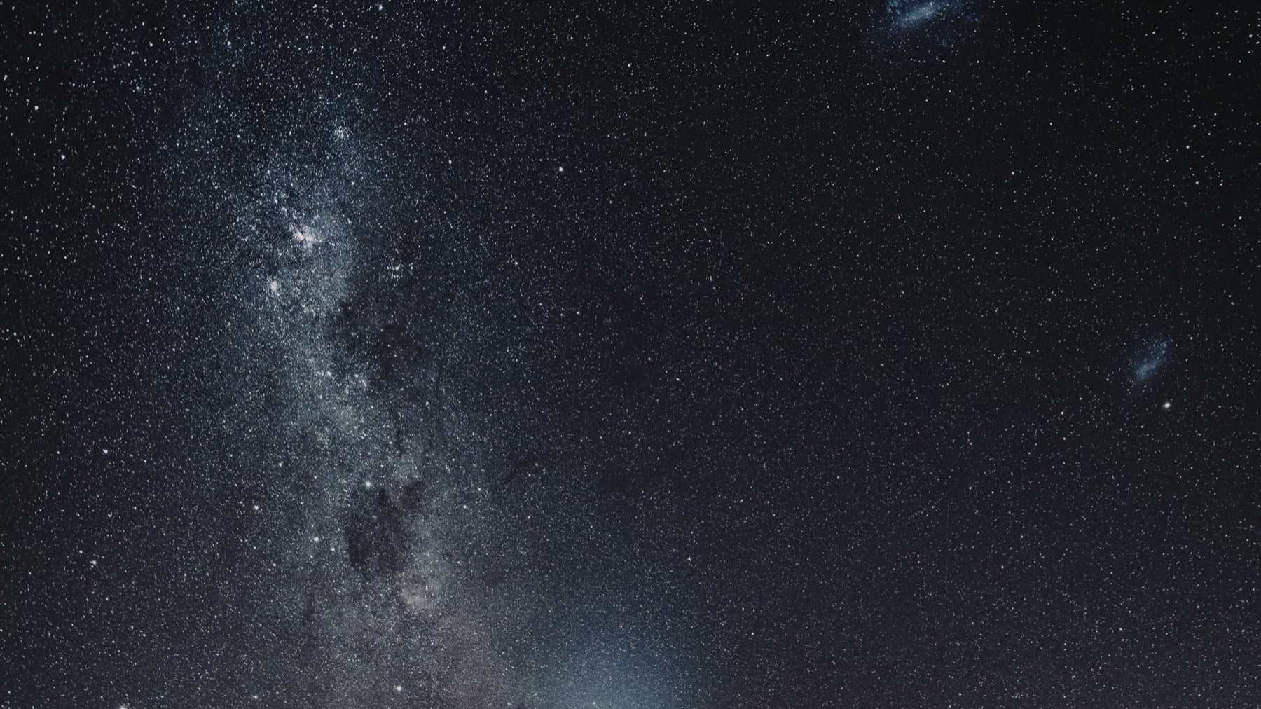 Milky Way over a dark treeline at night