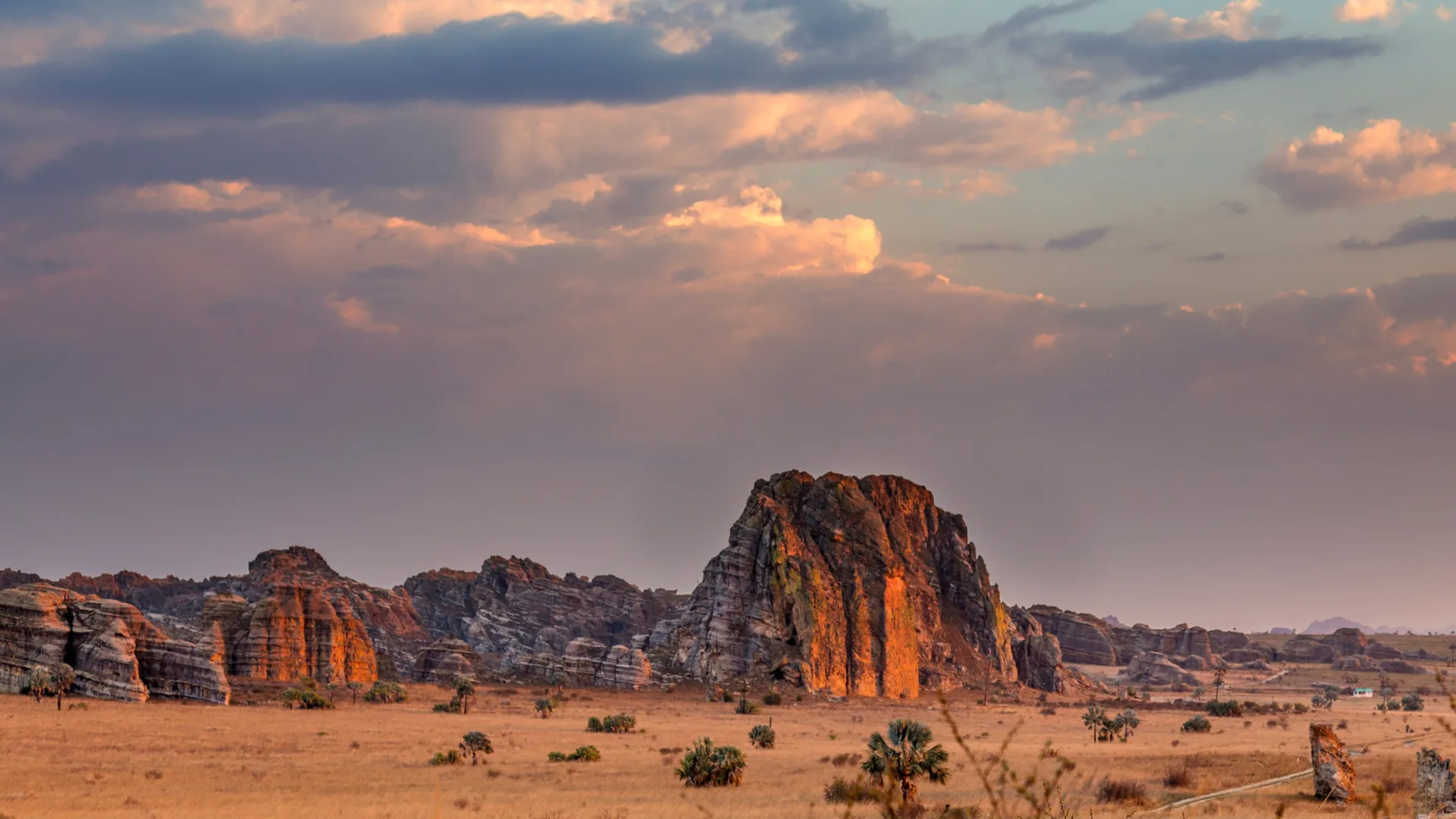 Sunlight breaking through clouds over a red-rock landscape