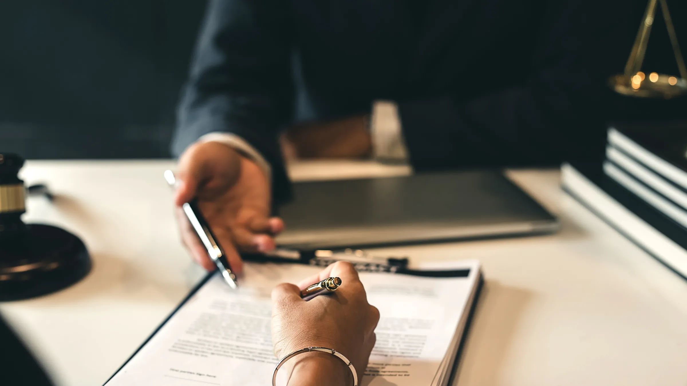 Hands signing a merchant agreement at a desk