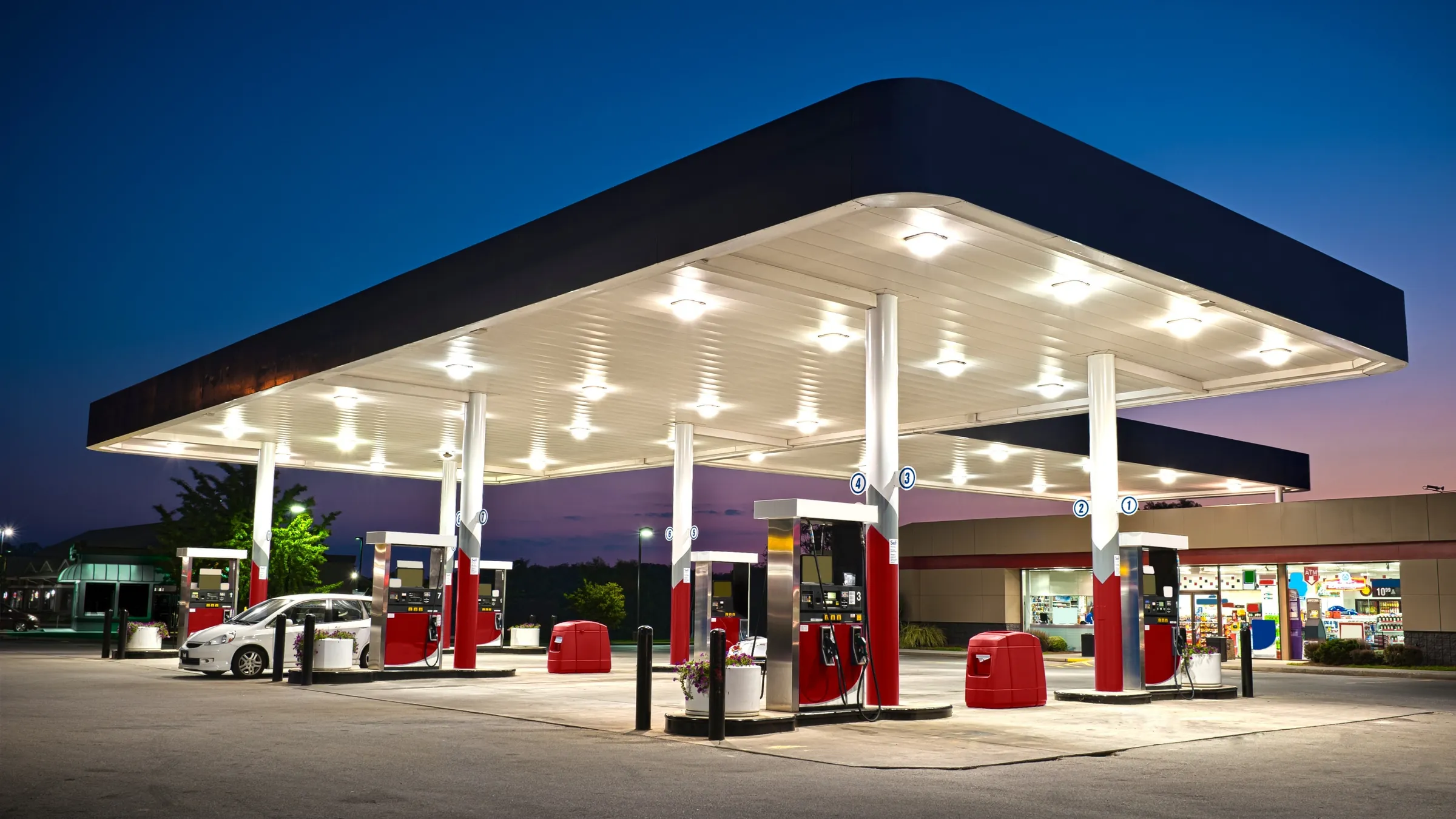 A lit gas station canopy at dusk