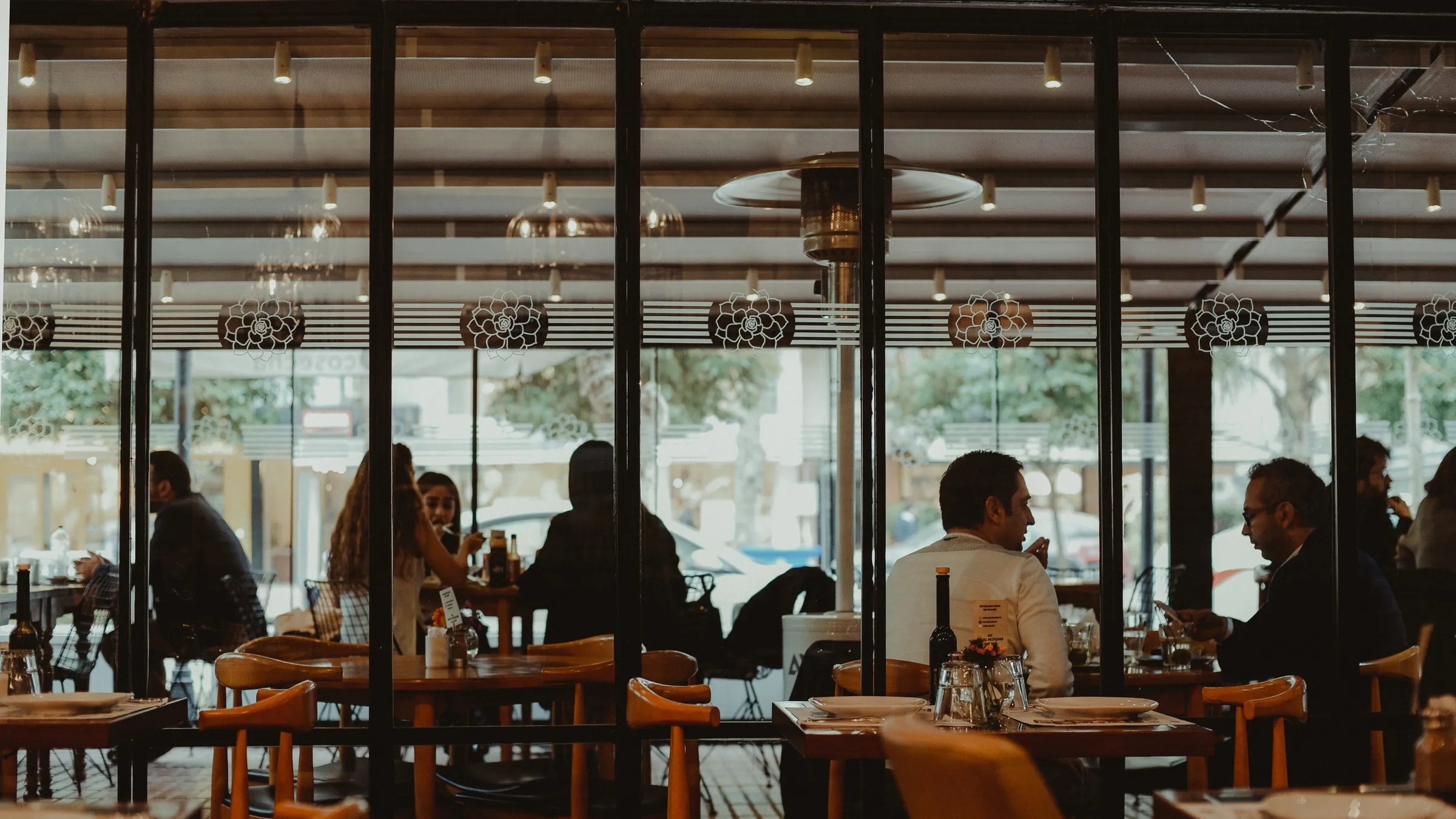 Diners seated inside a busy restaurant with large windows